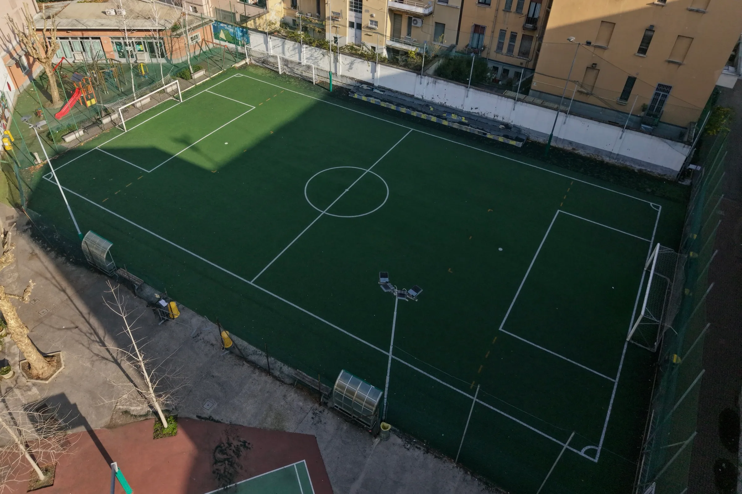 Campo da calcio a 7 in erba sintetica del pensionato universitario visto dall'alto