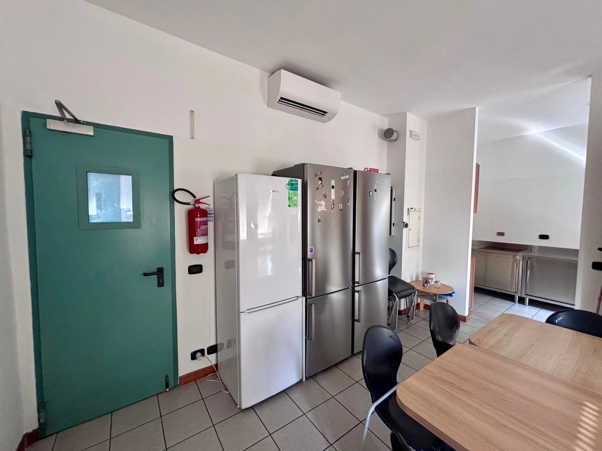 Frigoriferi e porta d'ingresso della cucina della residenza studenti