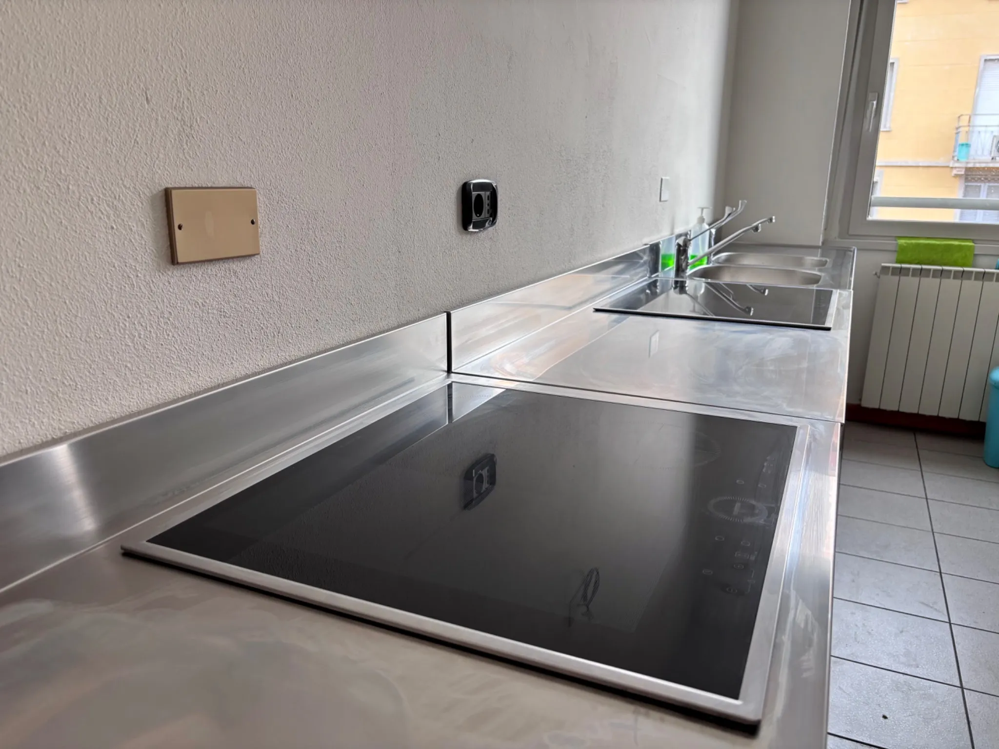Piano cottura a induzione con lavello in acciaio inox nella cucina studenti del Pensionato Bertoni